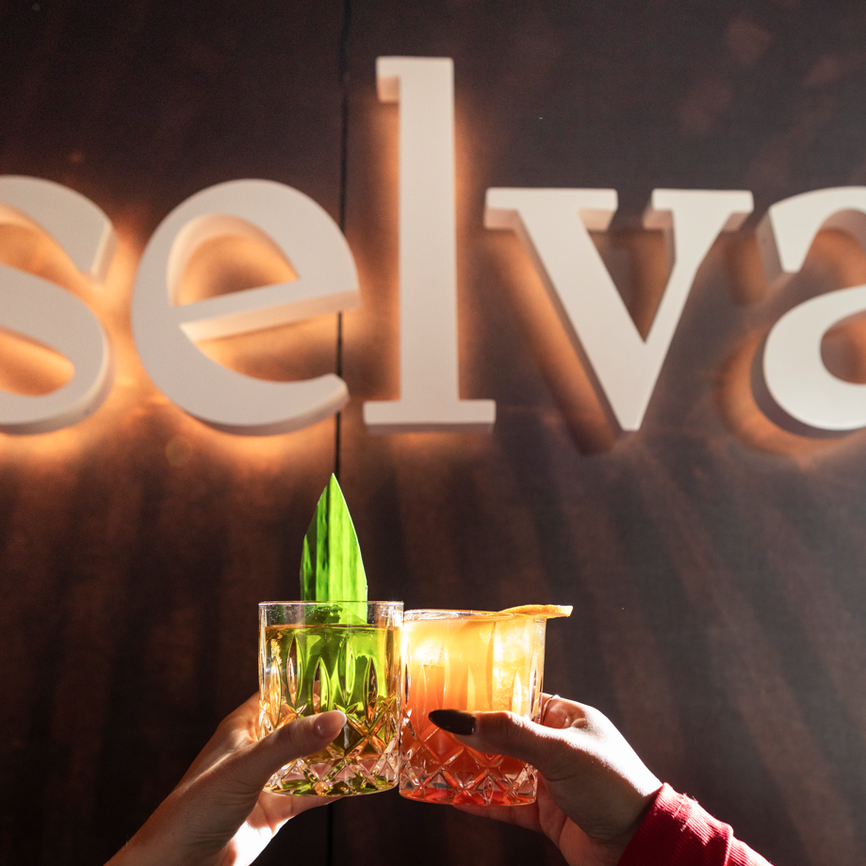 photo of two signature cocktails in front of selva sign at the emily hotel chicago